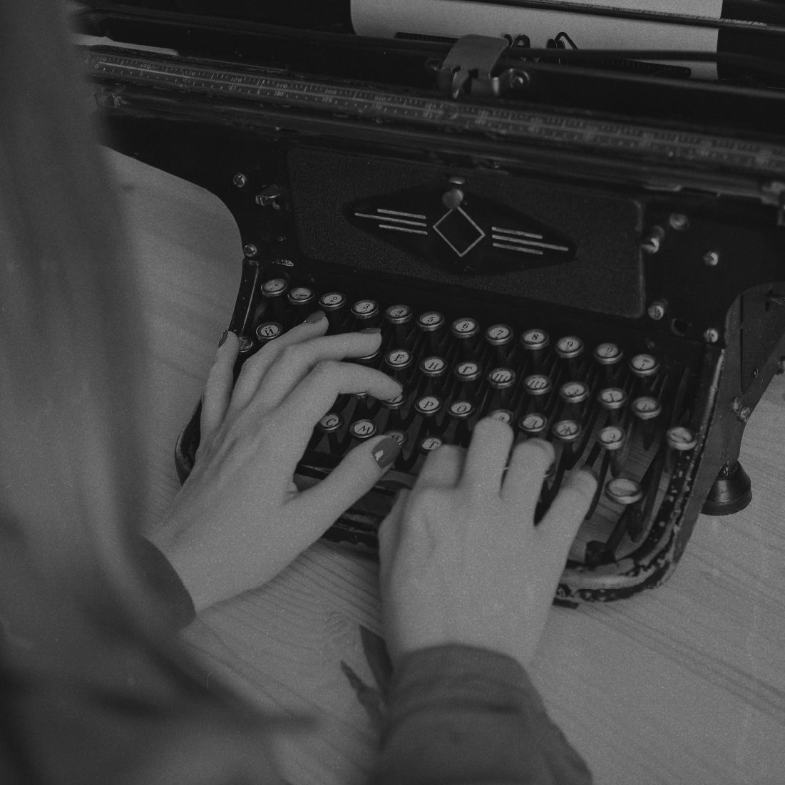A woman typing a letter on a typewriter.